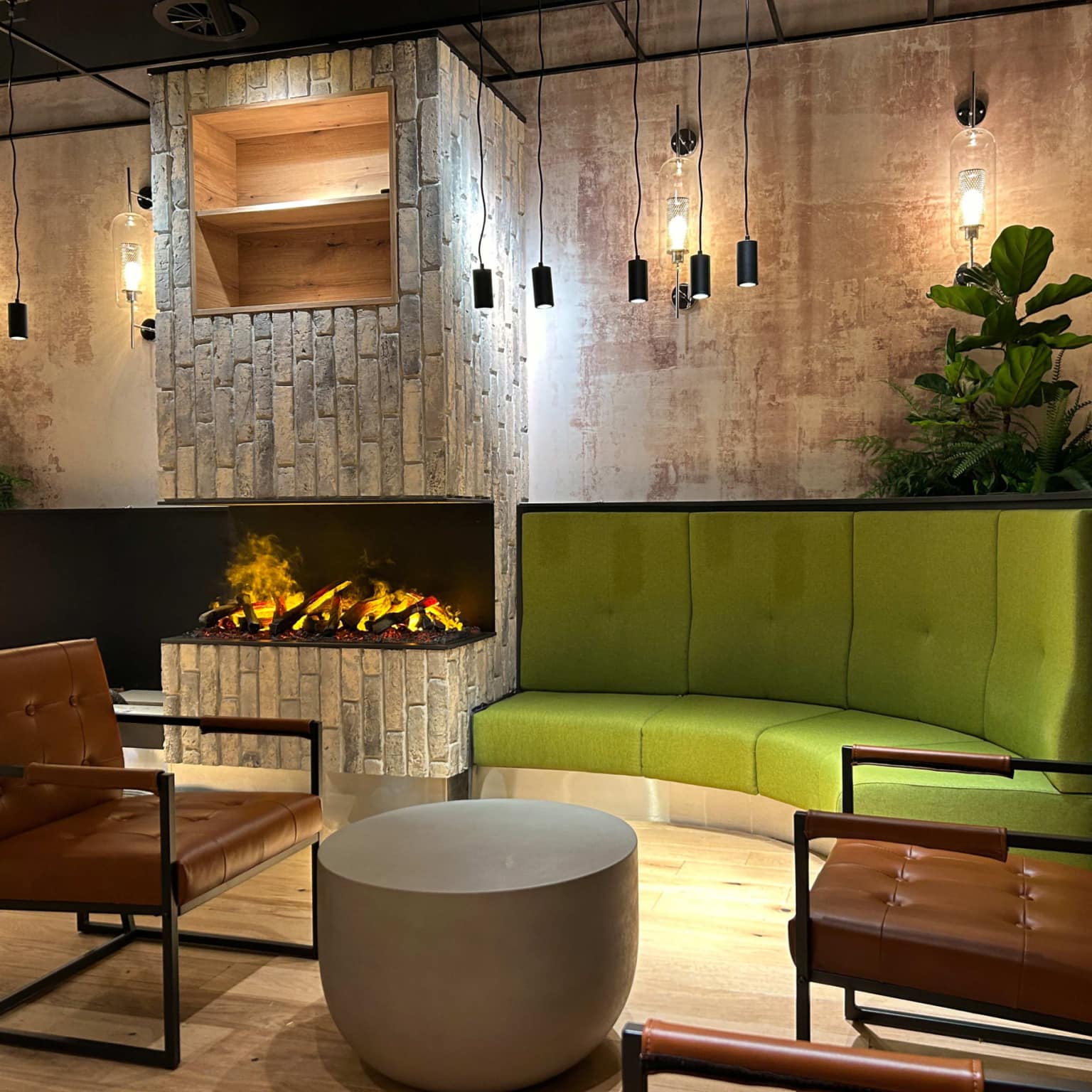 Foto von einer bequemen Loungeecke mit zwei Ledersesseln in einem Restaurant bei Dessau, im Hintergrund brennt ein Kaminfeuer