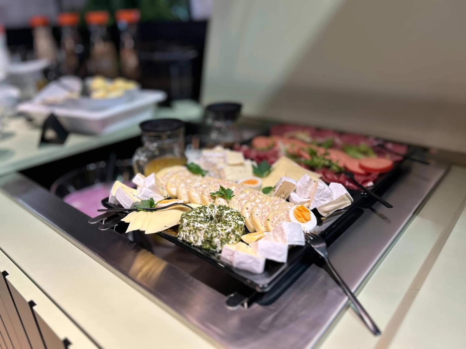 Nahaufnahme von einer Käseplatte als Teil eines Frühstücksbuffets in einem Restaurant bei Dessau, im Hintergrund sieht man weitere Speisen