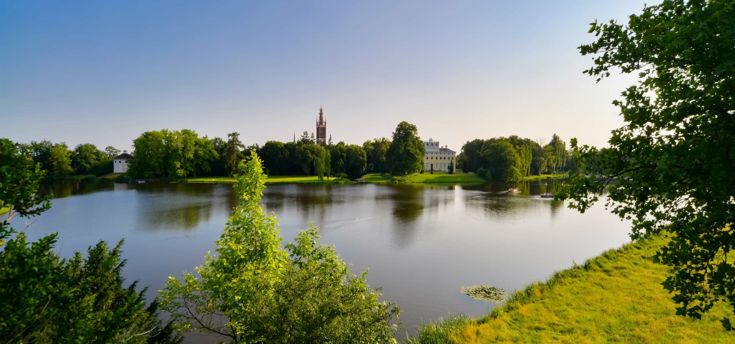 Foto vom Gartenreich Dessau-Wörlitz, einem beliebten Ausflugsziel mit imposanten Gebäuden und einem großen See in der Mitte