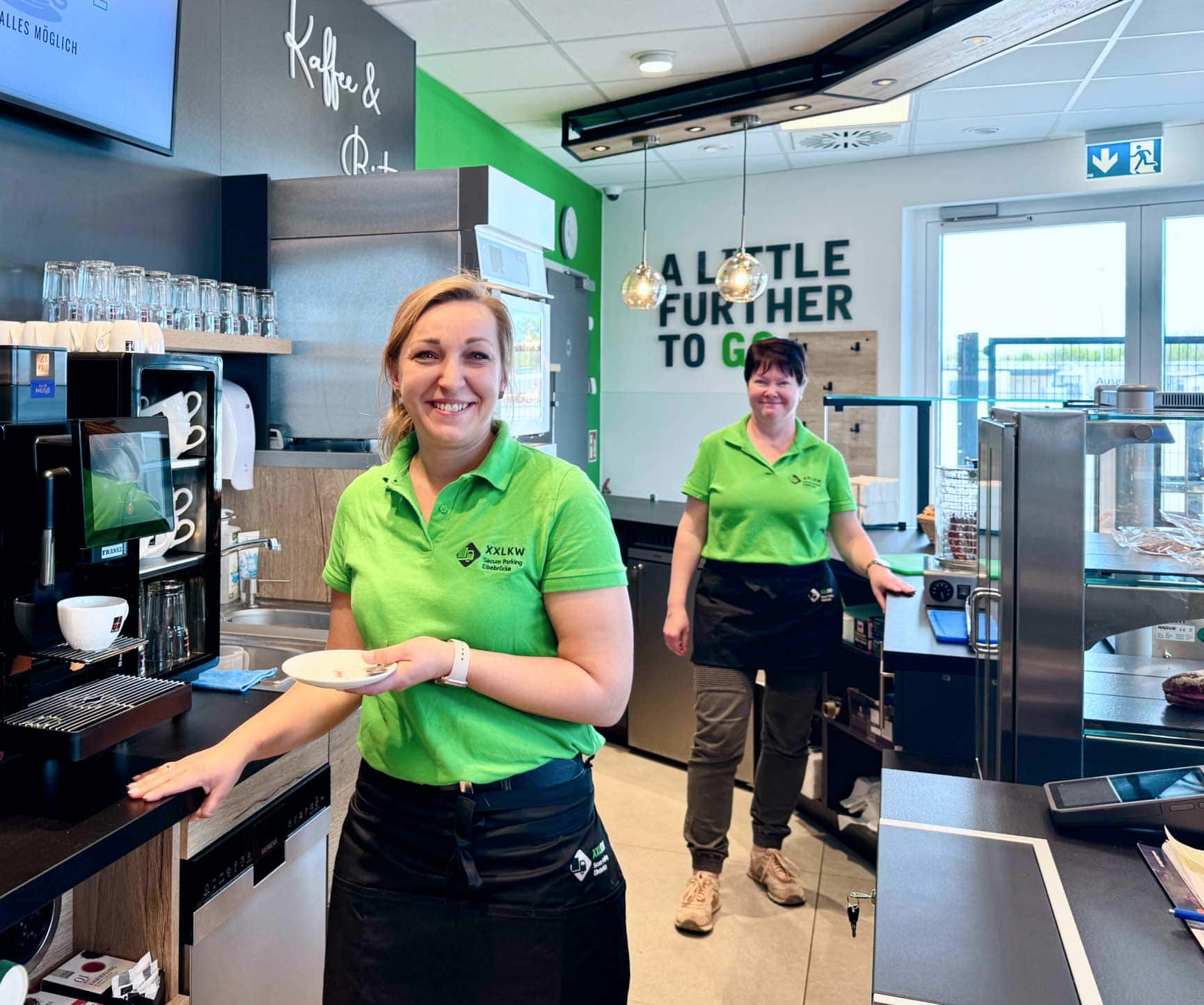 Zwie freundliche Bedienungen an einer Shop-Theke an der A9 beim Kaffee servieren